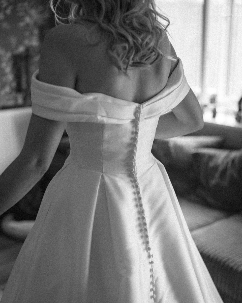 A woman in a wedding dress standing in a living room for a custom wedding dress design